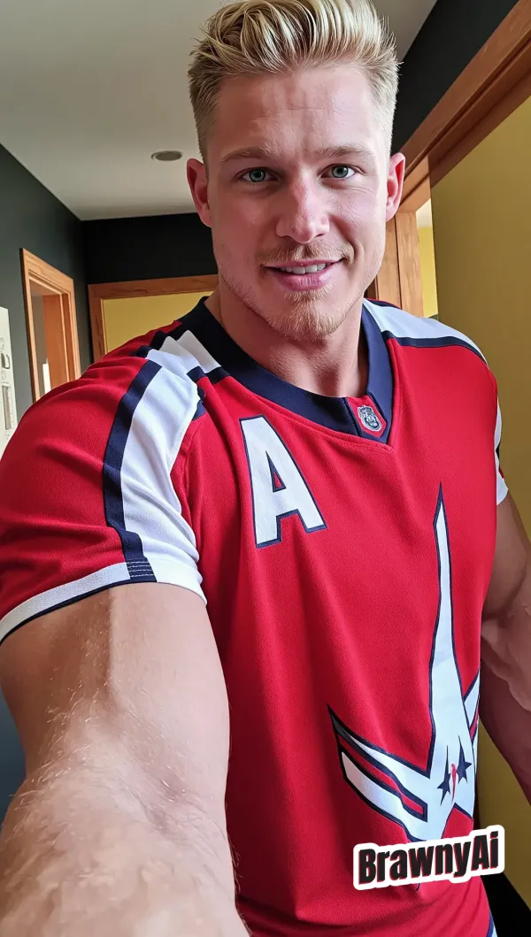 Muscular athlete in red captain's jersey with winged logo, soft daylight highlights on jawline and biceps, confident dir